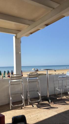 a group of chairs sitting on the beach at Mare Nostrum TF in Tre Fontane
