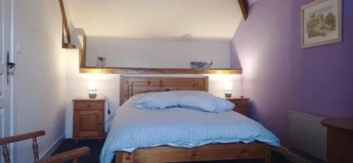 a bedroom with a bed and two night stands at Le Fry Holiday Gite in Lithaire