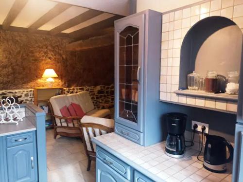 a kitchen with blue cabinets and a counter top at Le Fry Holiday Gite in Lithaire