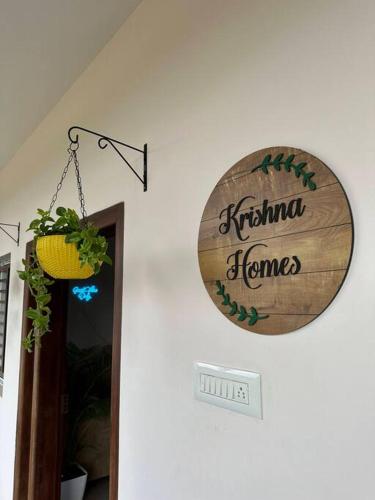 a sign that reads krishna frames hanging on a wall at Krishna Homes in Bengaluru