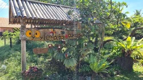 a sign in the middle of a garden at koh mook oyoy reggaebar bungalow in Koh Mook