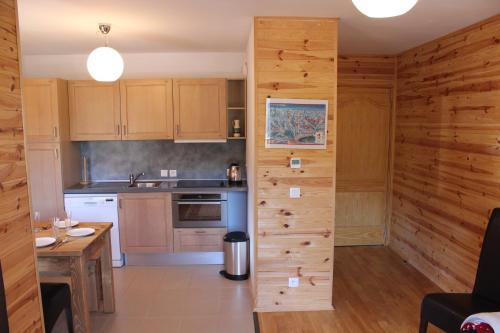 une cuisine avec un mur en bois au milieu dans l'établissement Lovely spacious apartment (+garage) in La Plagne, à Plagne 1800