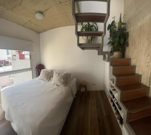 1 dormitorio con 1 cama y escalera de caracol en Apart Terraza en Palermo en Buenos Aires