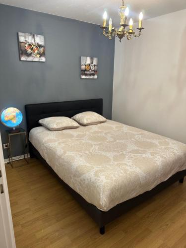 uma cama num quarto com um lustre em Ave de la vaite em Besançon