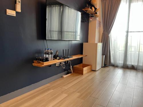 a living room with a wooden floor and a refrigerator at TainanHyggeAnping in Tainan