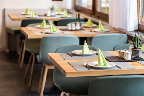 a row of tables in a restaurant with green chairs at Hotel Lindenhof Hubmersberg in Pommelsbrunn