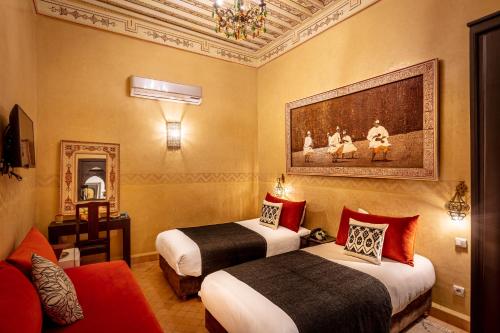 a hotel room with two beds and a painting on the wall at Riad & Spa Bahia Salam in Marrakesh