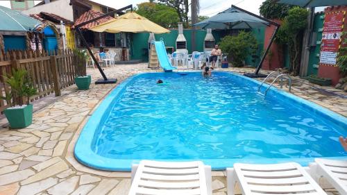 una gran piscina azul con sillas y un tobogán en Pousada Vila D' Itália, en Penha