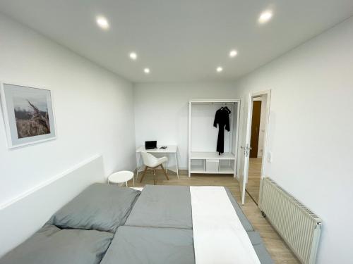 a white bedroom with a bed and a desk at Ferienwohnung Schönes Maifeld in Polch