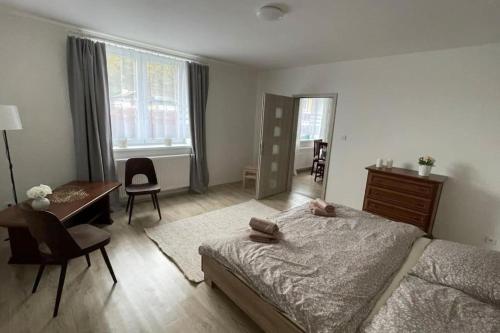 - une chambre avec un lit, un bureau et une table dans l'établissement Dům nad Jezerem - apartmán I., à Most