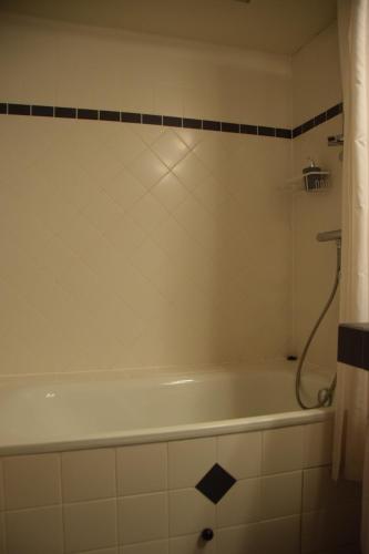a white bath tub in a bathroom with a shower at la Bodangeoise gîte rural in Fauvillers