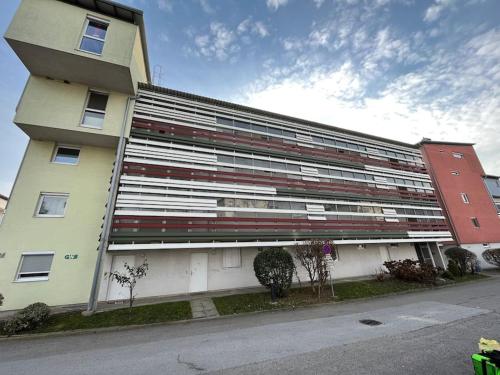 ein großes weißes Gebäude mit roten und weißen Fenstern in der Unterkunft Apartment in einer ruhigen Umgebung in Graz in Graz