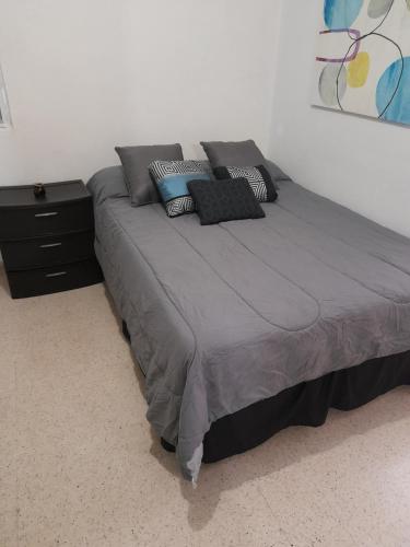 a large bed with pillows on it in a bedroom at Cozy Apartment across the San Juan Airport in San Juan