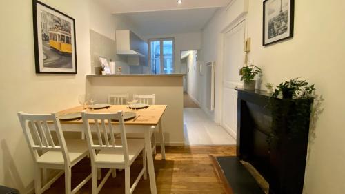 une salle à manger avec une table, des chaises et une télévision dans l'établissement L'occasion d'une pause, à Nevers