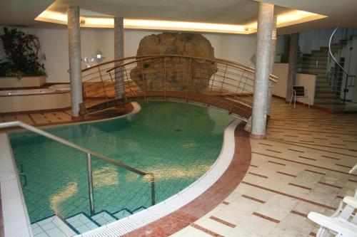 a swimming pool with a large tub in the middle of it at Hotel Krone in Brunico