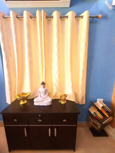 a room with a curtain and a dresser with two statues at SAND CASTLE in Konārka