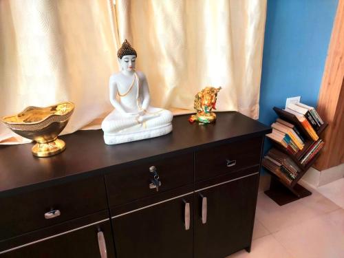 a statue of a buddha sitting on a dresser at SAND CASTLE in Konārka