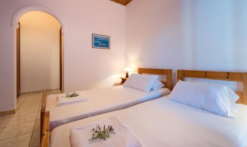 two beds in a room with white walls at Athena Studios in Vasilikos