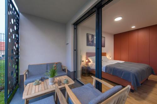 - une chambre avec un lit, une table et des chaises dans l'établissement Apartmaji Harpf, à Slovenj Gradec