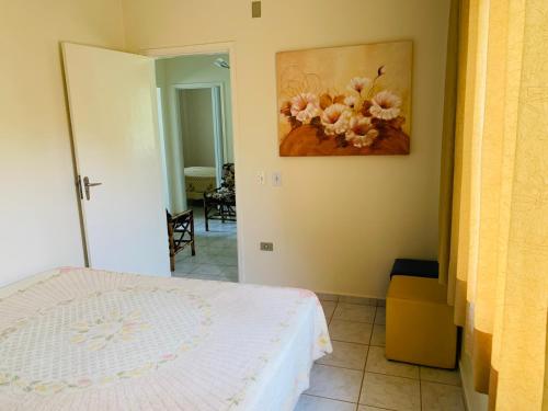um quarto com uma cama e um quadro na parede em Aguas de São Pedro ambiente Familiar e Aconchegante em São Pedro