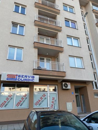 a building with a car parked in front of it at Apartman Nova Pale in Pale