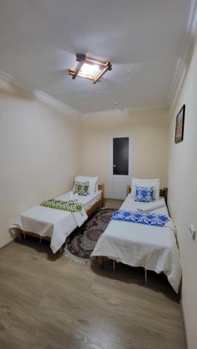 a room with two beds and a tv in it at Alisher B&B Hotel in Samarkand