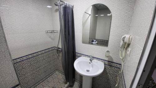 a bathroom with a sink and a shower and a mirror at Alisher B&B Hotel in Samarkand