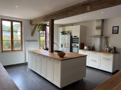 a kitchen with white cabinets and a wooden counter top at Maison de vacances dans un village de charme 