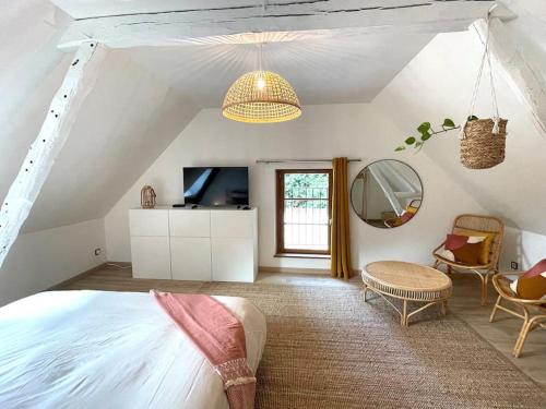 1 dormitorio con 1 cama y TV en una habitación en Maison de vacances dans un village de charme 