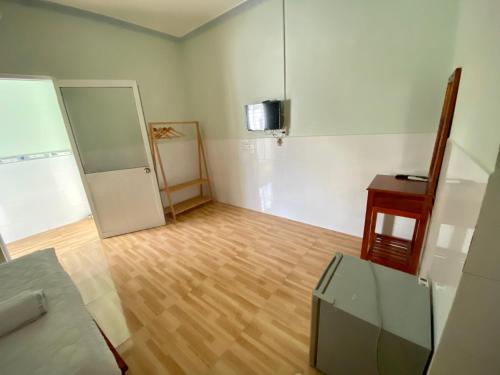 an empty room with a refrigerator and a wooden floor at Nhà Nghỉ Ý Vy in Phu Quoc
