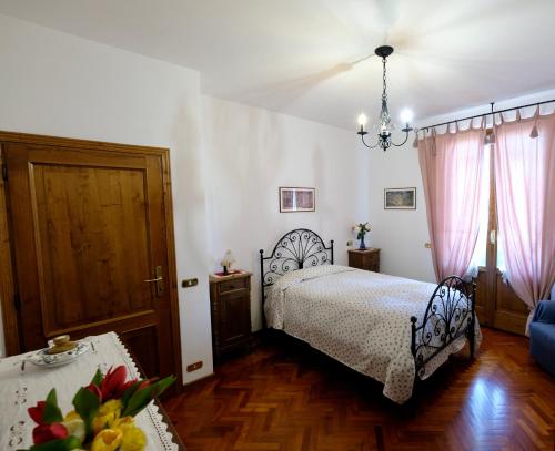 Un dormitorio con una cama y una mesa con flores. en Il Melograno - San Quirico d'Orcia, en San Quirico dʼOrcia