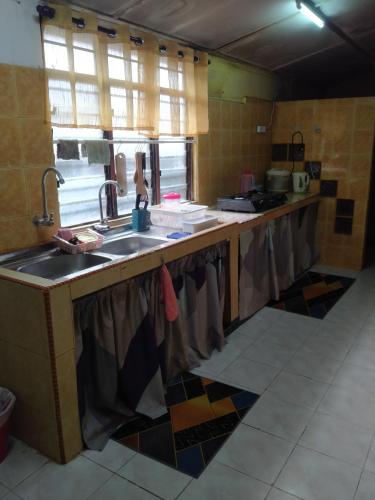 a kitchen with a sink and a counter top at Ali Homestay Desa Permai Bukit Kuang in Cukai