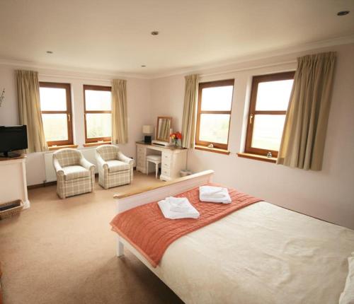 a bedroom with a bed with two towels on it at Ardmore luxury self catering cottage in Broadford
