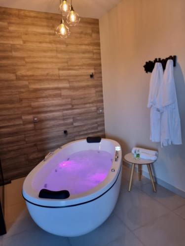 een badkamer met een bad met roze verlichting bij Hotel Itatiaia in Tangara da Serra