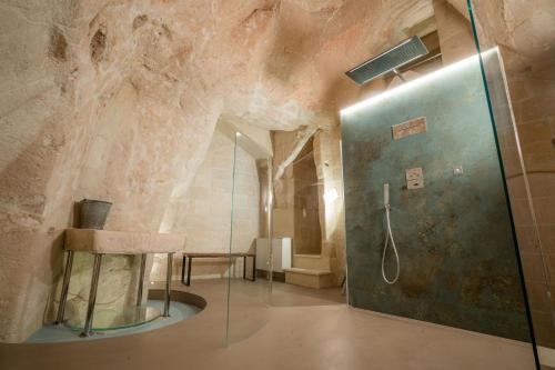 a bathroom with a shower with a rock wall at La Casa di Ele in Matera