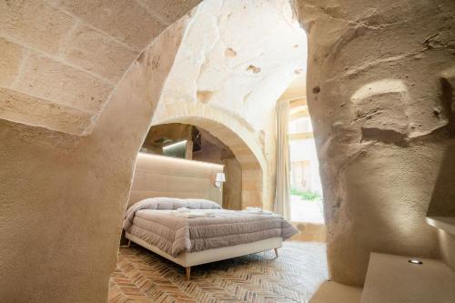 a bedroom with a bed in a stone wall at La Casa di Ele in Matera