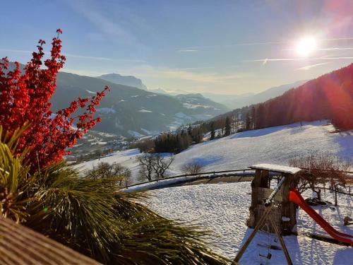 a view of a snowy mountain with the sun in the sky at Oberhauser Hof - Apartments in Feldthurns