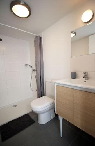 une salle de bain avec des toilettes blanches et un lavabo dans l'établissement Le Clos des Flots - La Dune, à La Flotte
