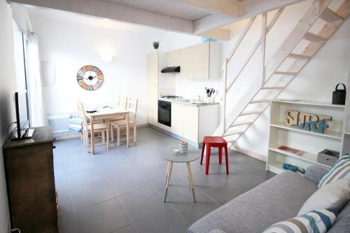 a living room with a couch and a table at Le Clos des Flots - La Dune in La Flotte