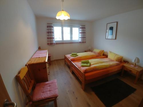 1 Schlafzimmer mit 2 Betten, einem Sofa und einem Fenster in der Unterkunft Haus am See in Tarasp