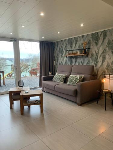 a living room with a couch and a table at Country house Au Ballet des Hirondelles in Herve