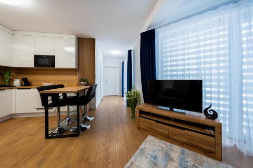 a living room with a flat screen tv and a table at AZURE PREMIUM Dreams in Kołobrzeg