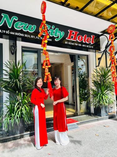 two women are standing in front of a hotel at NEW CITY HOTEL in Tây Ninh