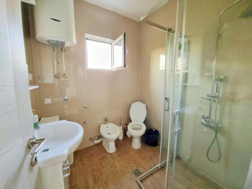 a bathroom with a toilet and a sink and a shower at Home Mia Airport in Podgorica