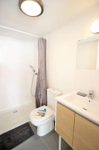 une salle de bain avec toilettes, lavabo et miroir dans l'établissement Le Clos des Flots - La Vague, à La Flotte