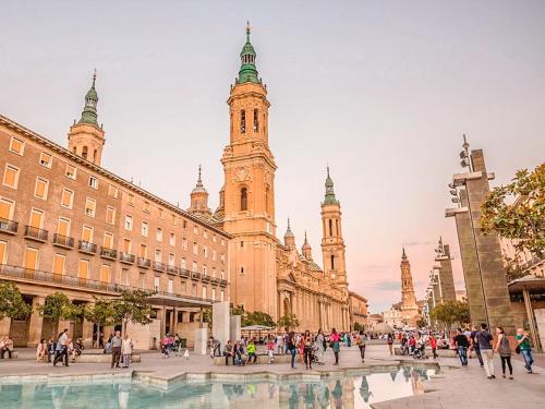 a group of people walking in front of a building at Gran piso pleno centro. Plaza del Pilar + Desayuno in Zaragoza