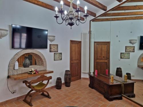 sala de estar con chimenea y TV en la pared en Casa Vacanze Nives, en Tuscania