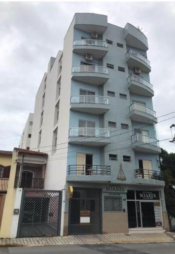 a tall white building with balconies on the side of it at Pousada Soares in Aparecida