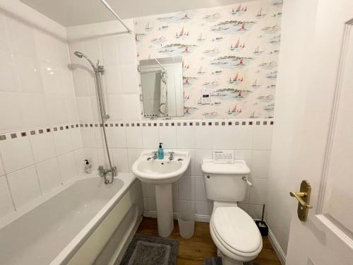 a bathroom with a sink and a toilet and a bath tub at Wilce House in Wellingborough