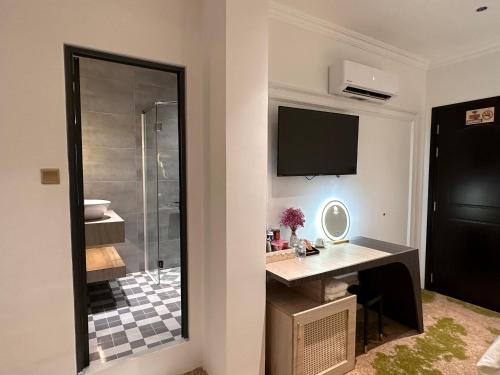 a bathroom with a shower and a desk with a mirror at Phước Hưng 3 Hotel in Vĩnh Long